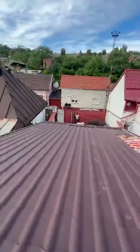 Țiglă metalică maro montată peste folie și șipcă, urcând spre coamă.