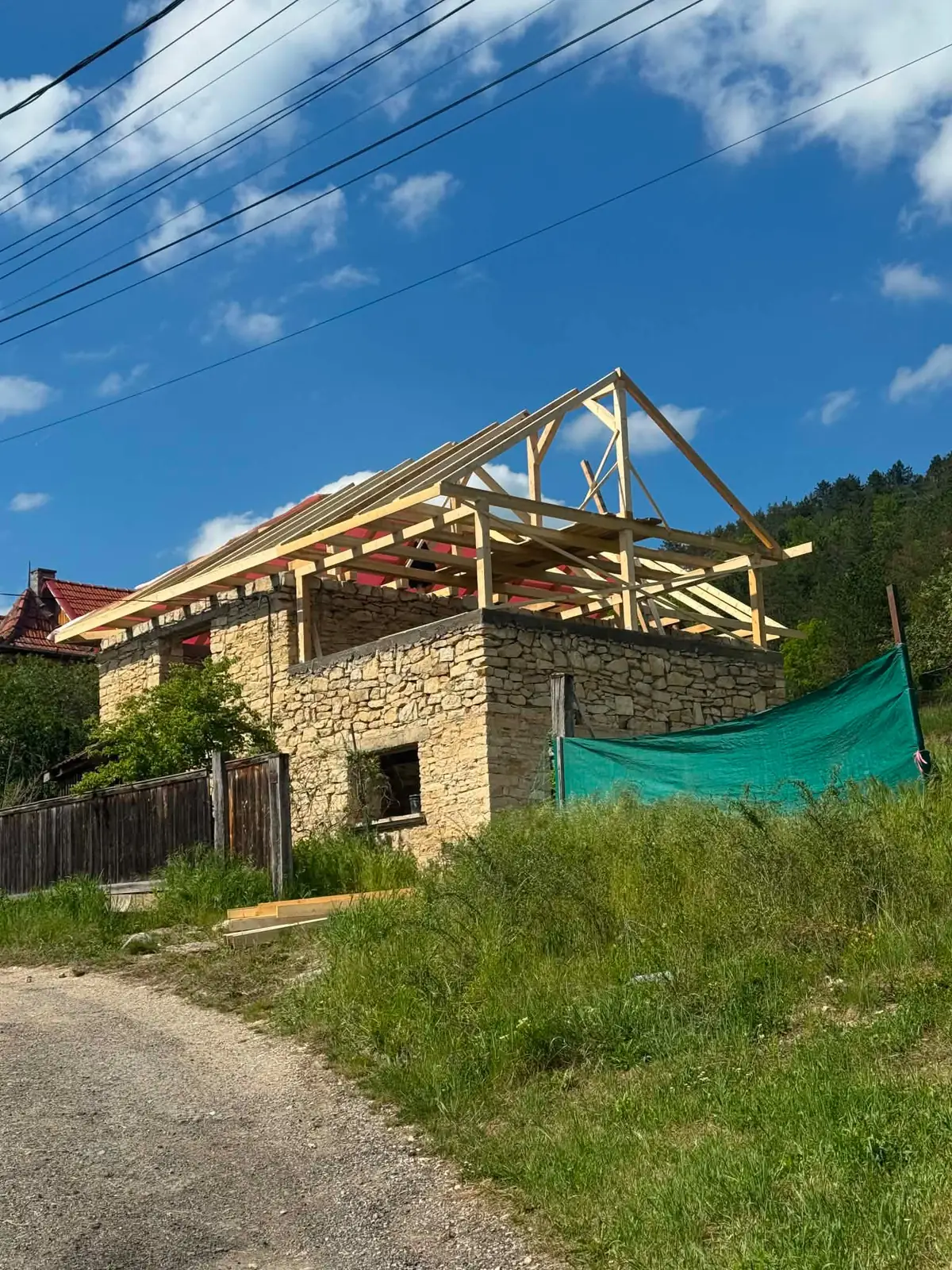Șarpantă nouă de lemn, ridicată peste zidăria de piatră a unei case