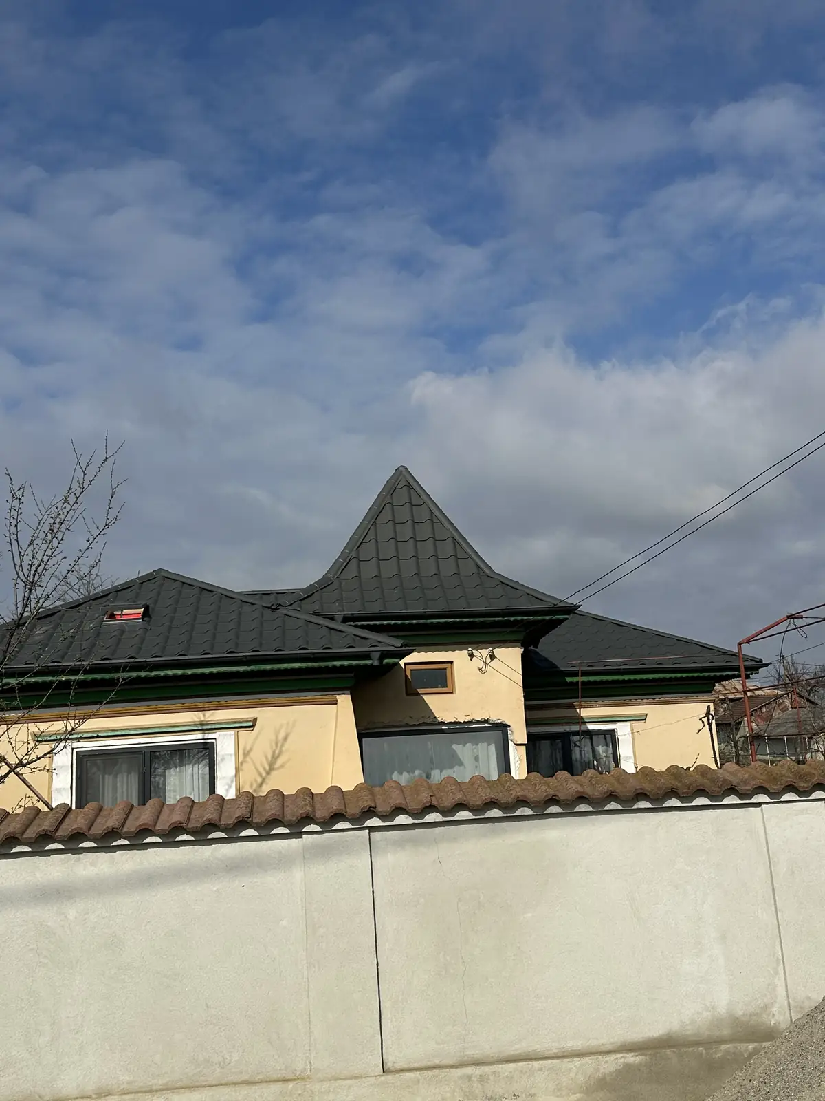 Casă cu acoperiș nou din țiglă metalică grafit și turn conic, la finalul montajului